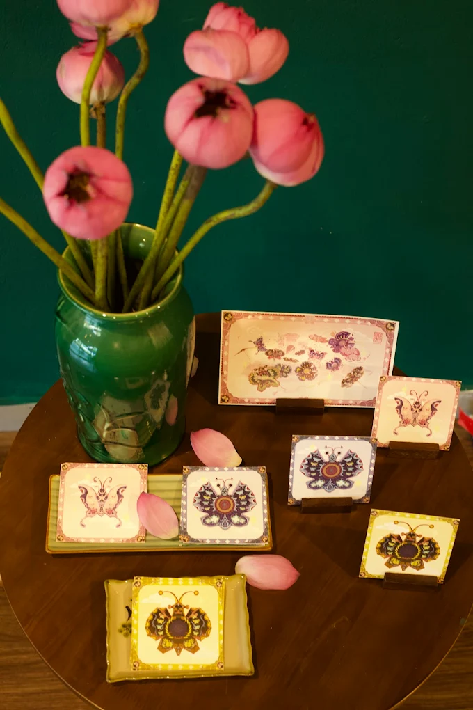 Illustrated butterfly souvenir cards displayed on a wooden table
